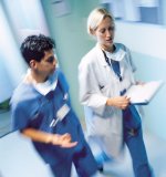 Female Physician walking next to s male Nurse in a Hospital